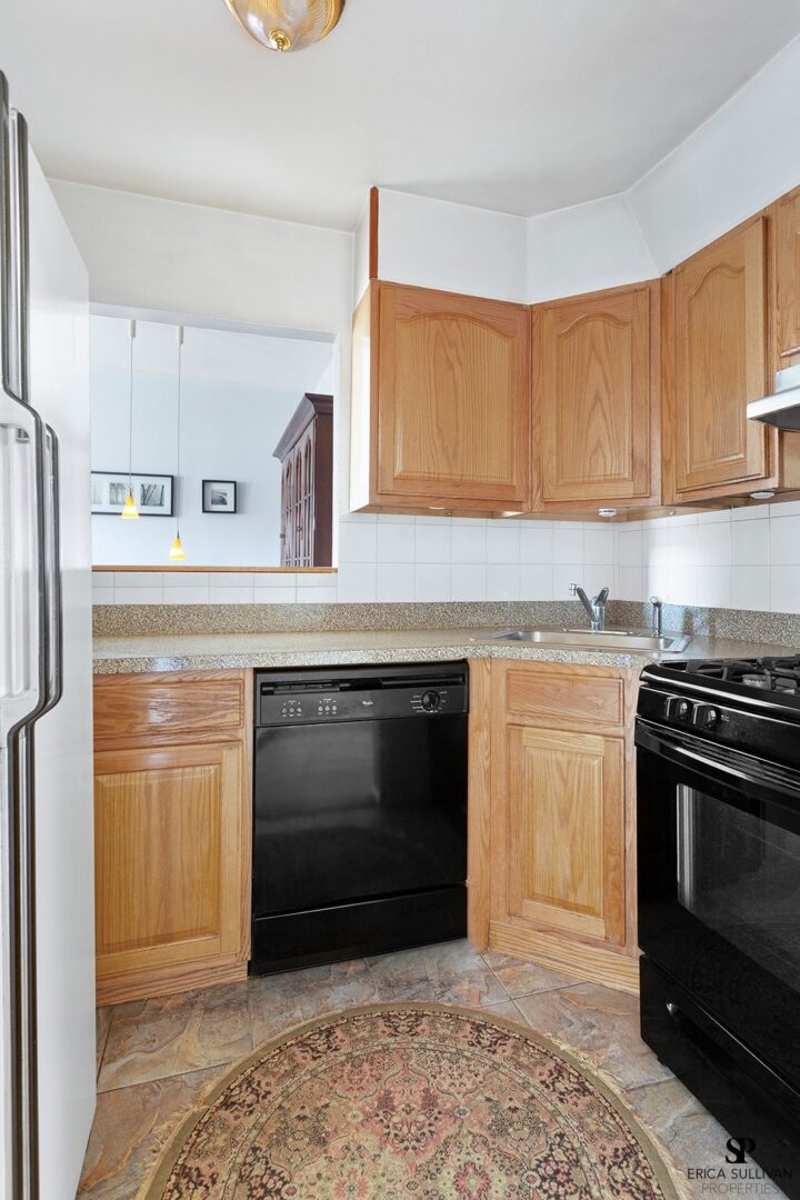 A kitchen with wooden cabinets and black appliances.