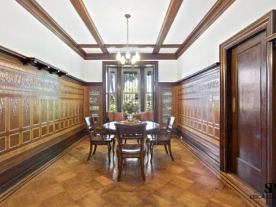 A dining room with wood paneled walls and floors.