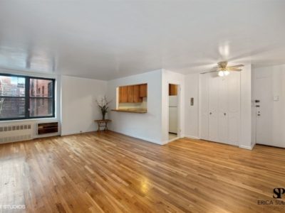 A living room with hard wood floors and white walls.