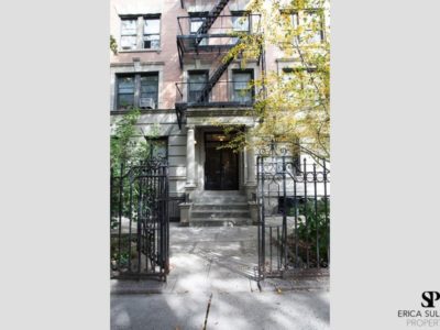 A building with stairs and fire escape on the side.