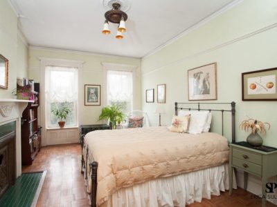 A bedroom with a bed, dresser and window.