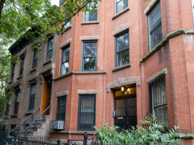 A brick building with many windows and trees