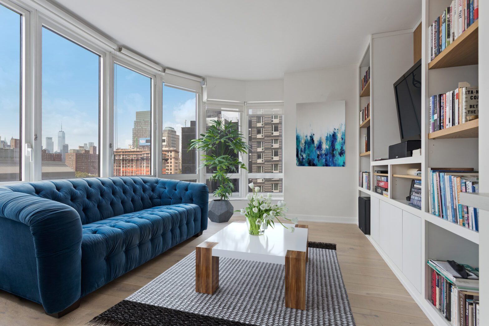 A living room with a blue couch and white walls