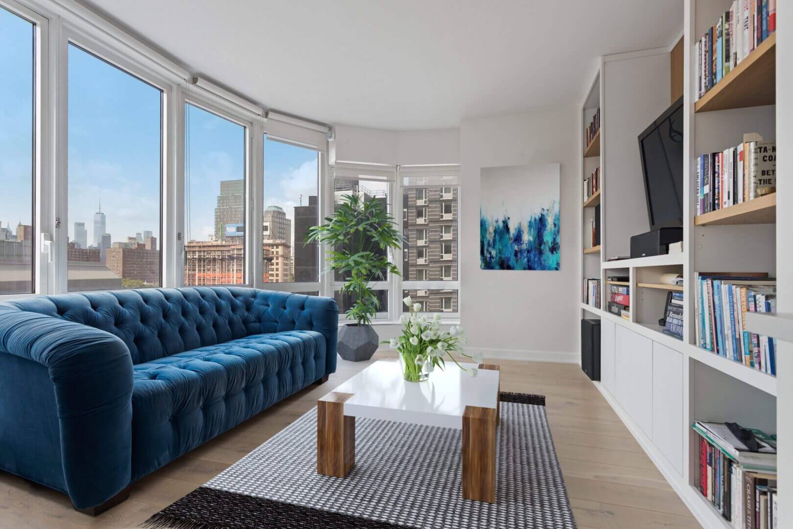A living room with a blue couch and white walls
