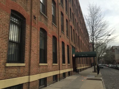 A building with many windows and a sidewalk.