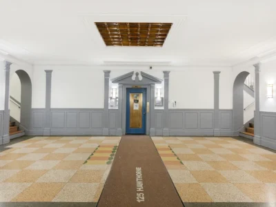 A room with a blue door and a brown carpet.