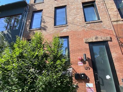 A brick building with a tree in front of it.