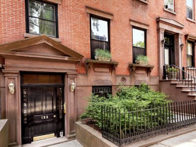 A brick building with plants growing in the front.