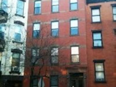 A red brick building with many windows and doors.